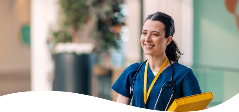 A nurse with a stethoscope around her neck is holding a yellow folder