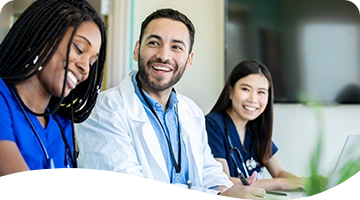 Healthcare team members smiling while sitting together at a table