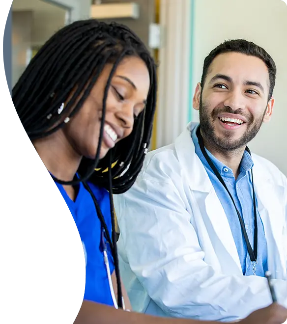 Healthcare team members smiling while sitting together at a table