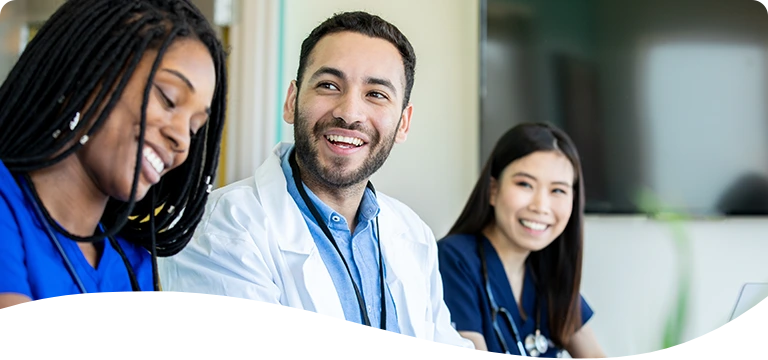 Healthcare team members smiling while sitting together at a table